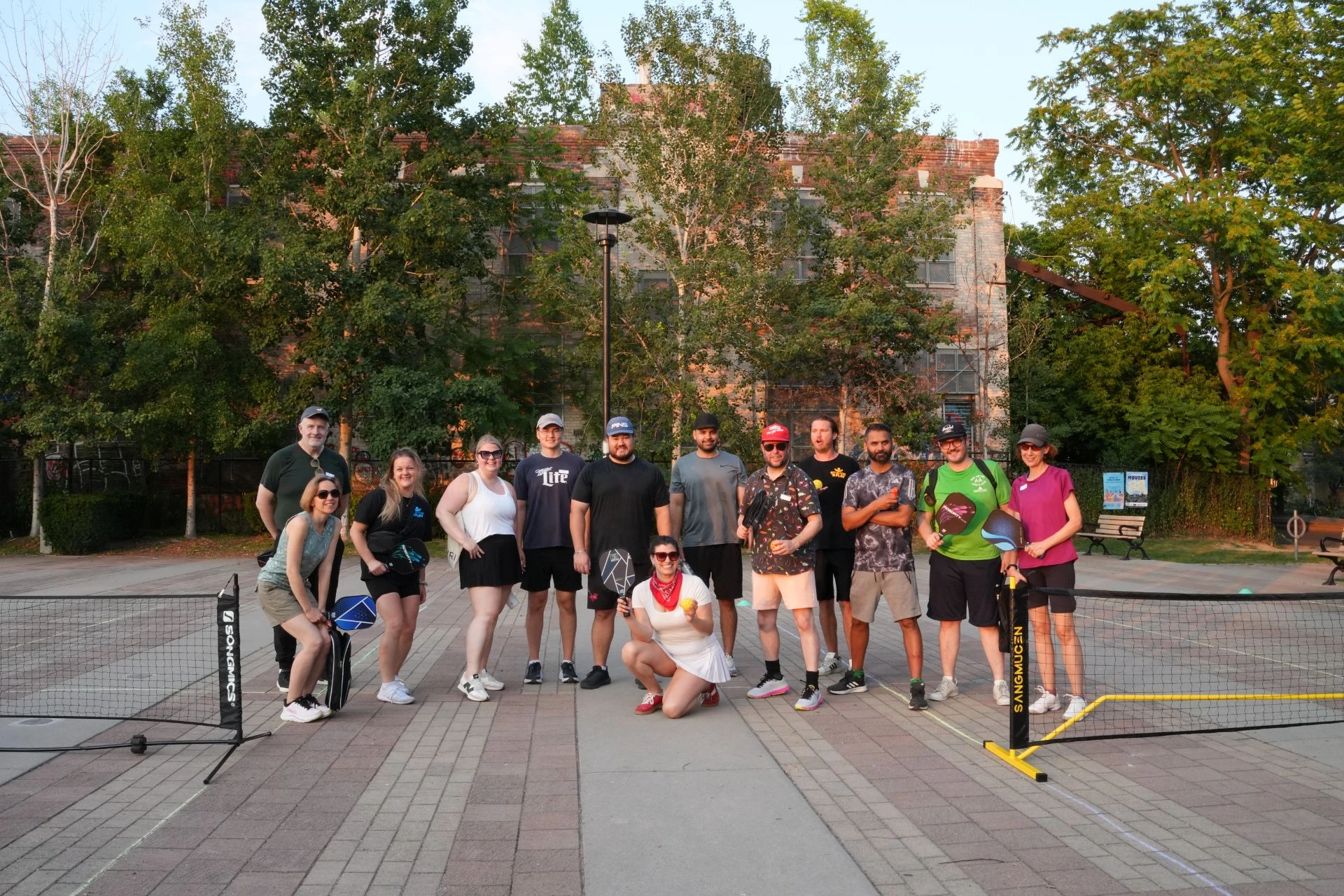 Neighbours standing together with paddles after a Saturday pickleball session at Sorauren Park