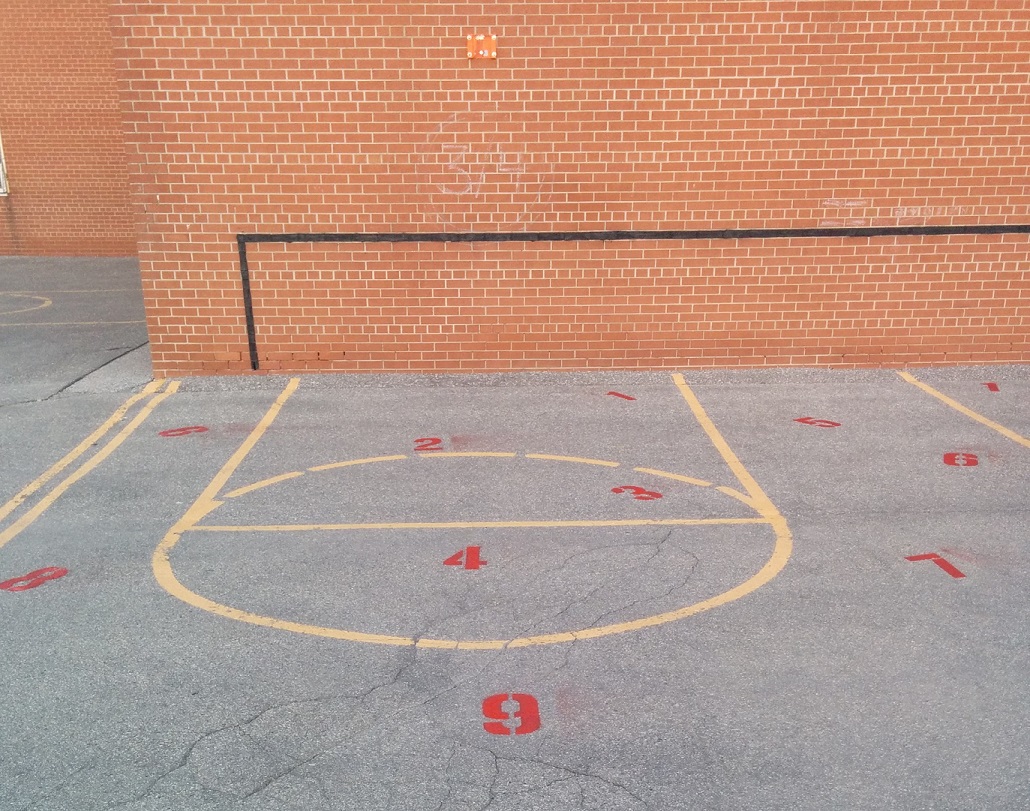 Numbered court markings painted on a schoolyard wall