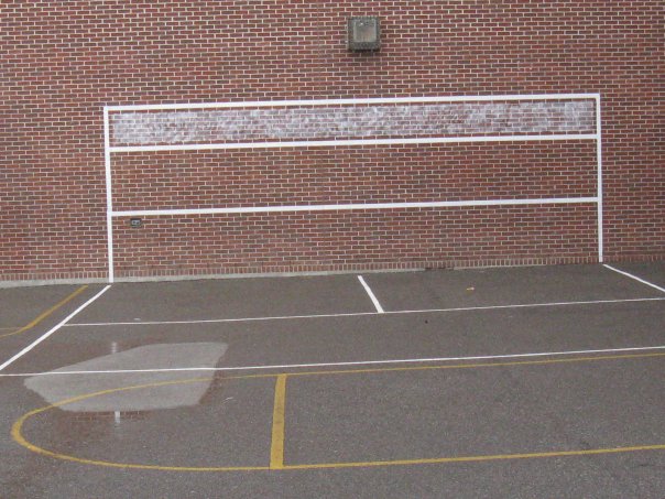 An early white tennis and volleyball Sportswall painted on a brick school wall